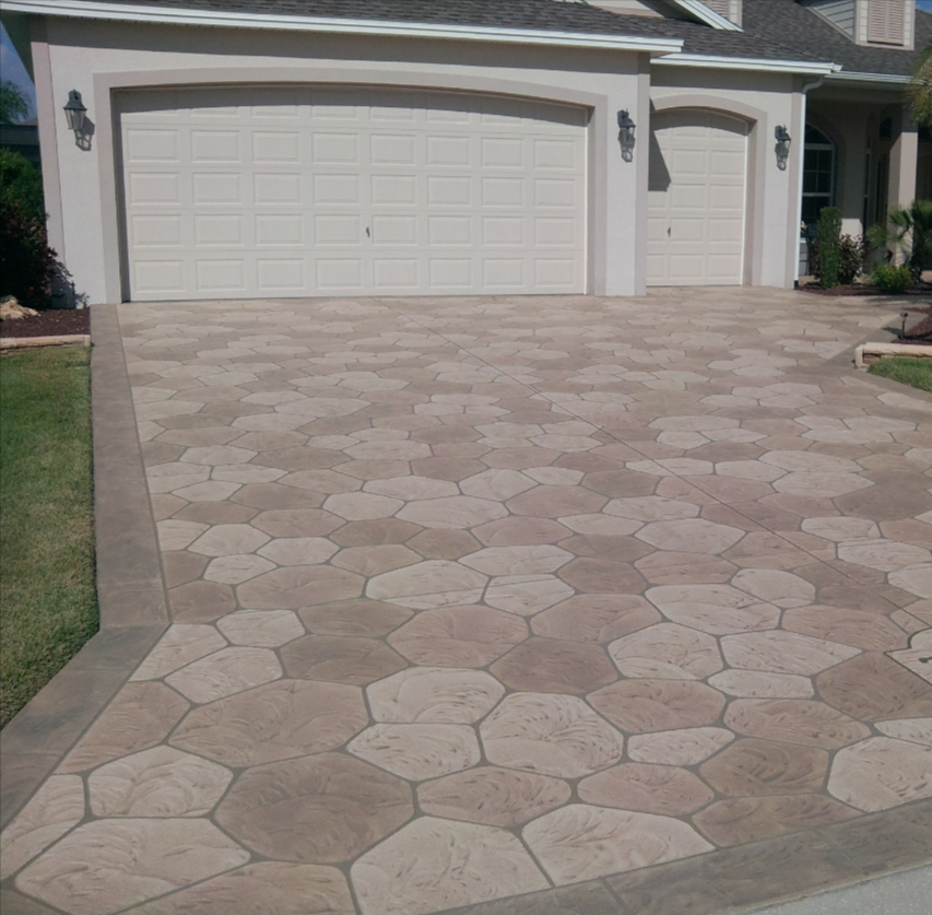 Stamped concrete driveway poured by Louisville Professional concrete.  It has a polygonal stamped stone pattern and varied stained colors to each stone.